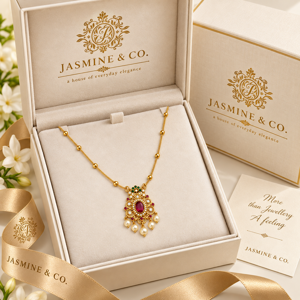 Gold-plated red stone pendant necklace in Jasmine & Co. packaging box